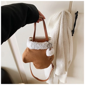 Detail of creative glove-shaped crossbody bag with white plush trim and fuzzy ball charm