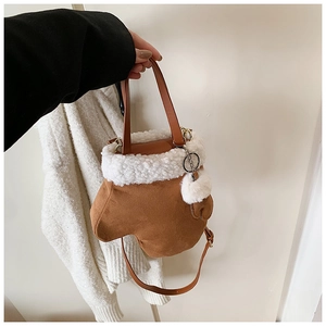 Detail of creative glove-shaped crossbody bag featuring brown suede and white faux fur trim