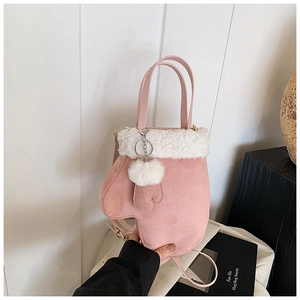 Detail of pink glove-shaped handbag with white faux fur trim and fluffy pompom charm