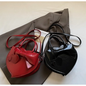 Vue détaillée des sacs à main en forme de cœur avec nœuds en couleurs rouge et noir