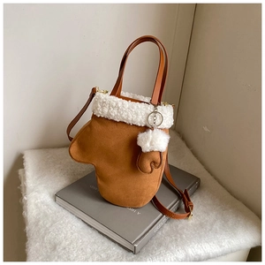 Close-up of brown suede bucket bag with white fleece trim and cute mini glove charm