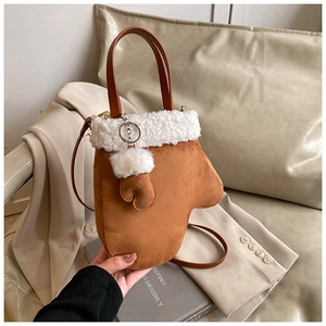 Detail view of a brown suede glove-shaped handbag with plush white faux fur trim