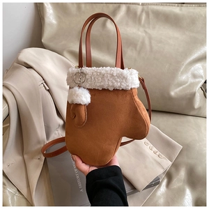Detailed view of plush brown mitten-shaped handbag with soft white shearling trim