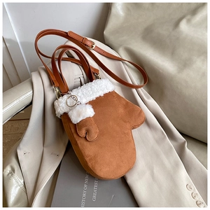 Detailed macro of the unique brown mitten-shaped crossbody bag with soft faux fur trim