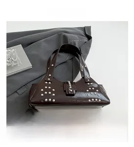 Détails du sac en cuir verni marron foncé avec rivets argentés et boucle rétro