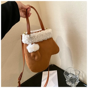 Close-up of brown suede glove-shaped handbag with white faux fur trim and pompom detail