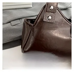 Gros plan détaillé sur le cuir brillant marron foncé avec rivets argentés