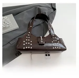 Vue de dessus d'un sac à main punk marron foncé avec clous argentés et texture cuir lisse