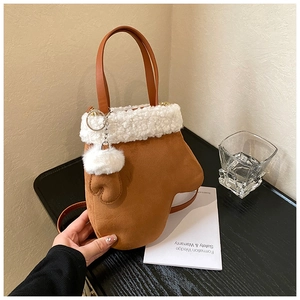 Detail of creative glove-shaped brown plush handbag with white faux fur trim and fluffy pompom