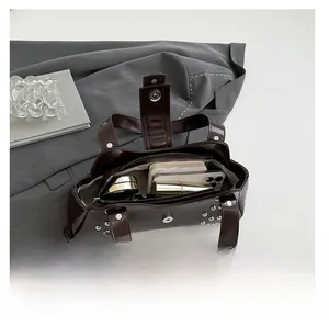 Détail macro de l'intérieur spacieux avec rivets et poche zippée du sac en cuir marron