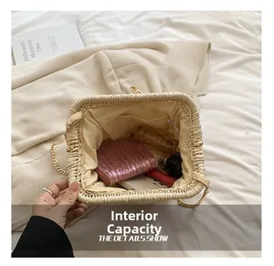 Detail view of woven straw clutch showing inner pocket and capacity with personal items