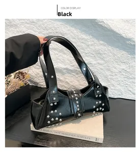 Détail d'un sac à bandoulière punk noir avec clous argentés et finition en cuir brillant