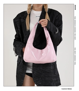 Nahaufnahme der rosa Lackleder-Hobo-Tasche mit Schleifendetails und silbernen Nieten