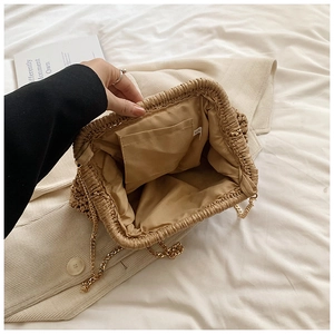 Interior view of straw woven clutch bag with gold chain strap and fabric lining