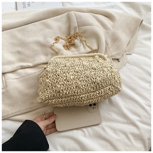 Detail of cream handmade woven cloud bag with textured waves and gold chain strap
