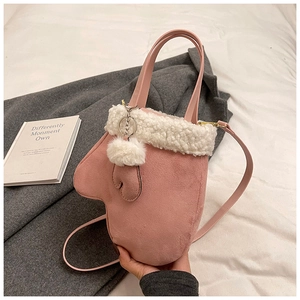 Detailed macro of pink suede glove-shaped handbag featuring soft white shearling trim