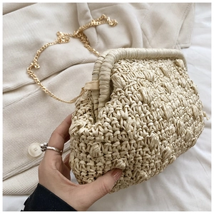 Detail of beige woven cloud clutch with spherical texture and gold chain strap
