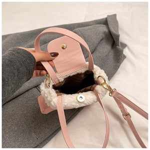 Close-up of pink faux leather bag with white sherpa trim and magnetic gold closure