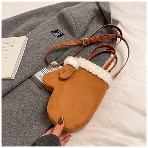 Detail of camel glove-shaped handbag with white faux fur trim and adjustable crossbody strap