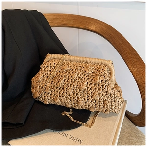 Macro shot of 3D textured ball-weave pattern on light brown straw cloud clutch