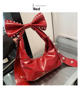 Detail einer roten Lackhandtasche mit großer Schleife und silbernen Metallnieten-Besatz