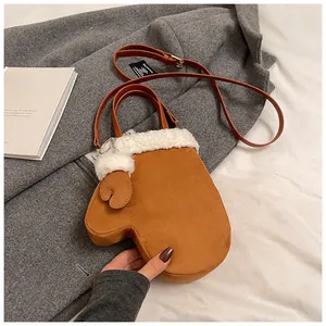 Detailed view of the brown glove-shaped plush crossbody bag with white shearling trim