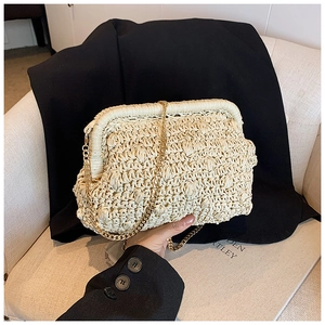 Detail of cream woven cloud clutch with textured straw pattern and gold chain strap
