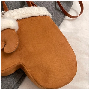 Close-up of brown faux suede mitten-shaped crossbody bag with white faux fur trim