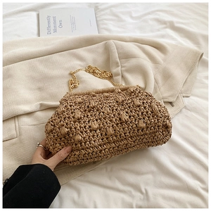 Detailed view of brown handmade woven clutch with unique bubble texture and gold chain