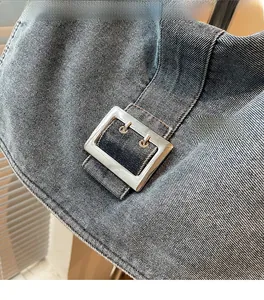 Detail of light blue denim fabric texture and silver rectangular metal buckle closure