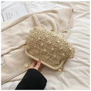 Detail of hand-woven straw bag texture with elegant gold chain and cloud folding