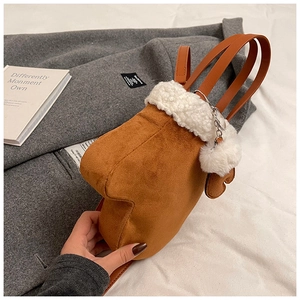 Detail of creative glove-shaped crossbody bag with brown suede and white faux fur trim