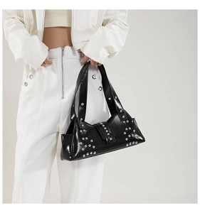 Détail du sac hobo noir brillant style punk avec des clous argentés et une boucle