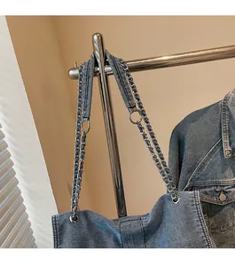 Detail of silver metal chain strap with denim fabric weave on blue shoulder bag
