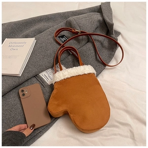 Detail of creative glove-shaped crossbody bag featuring brown suede and faux shearling trim