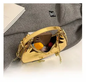 Vue détaillée de l'intérieur d'un sac demi-lune doré avec rangement maquillage