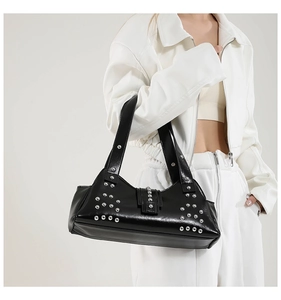 Détail du sac hobo punk en cuir PU brillant avec des rivets argentés sur la bandoulière
