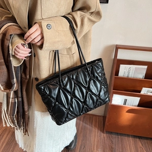 Chic black quilted tote bag with diamond pattern and slim straps for office commuting