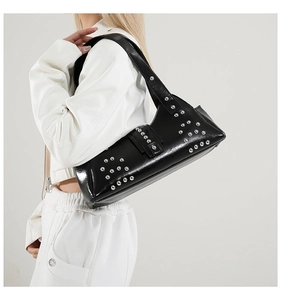 Détail du sac sous l'aisselle punk noir avec rivets argentés porté sur l'épaule