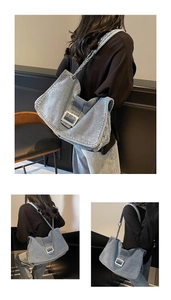 Three-way view of light blue denim shoulder bag with silver buckle and chain strap