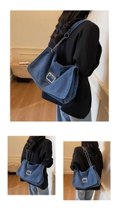 Detail of blue denim shoulder bag featuring a large silver buckle and chain strap