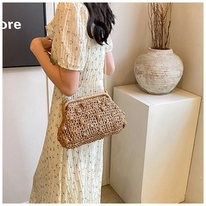 Detail of hand-woven dark brown straw dumpling bag with unique bubble texture and gold chain