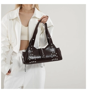 Détail d'un sac à main en cuir chocolat noir avec rivets argentés et style punk