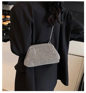 Detailed close-up of a silver rhinestone cloud bag with a metal chain on a black blazer