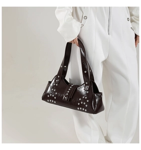 Détails de la texture en cuir verni et des rivets argentés sur le sac à main style punk