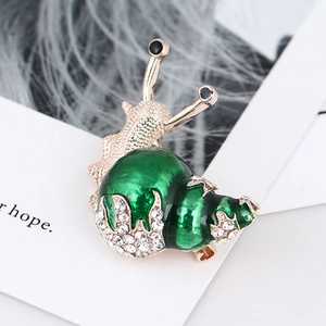 Detailed view of rose gold snail brooch with green enamel and sparkling rhinestones