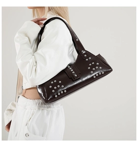 Détail du sac en cuir marron foncé avec rivets métalliques argentés et fini poli