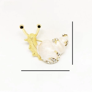 Detailed view of snail brooch with enamel shell and sparkling crystal rhinestones