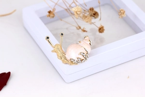 Detailed macro shot of snail brooch with pink enamel and sparkling crystals