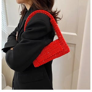 Detail of red beaded woven handbag showing the glossy resin beads and stylish texture